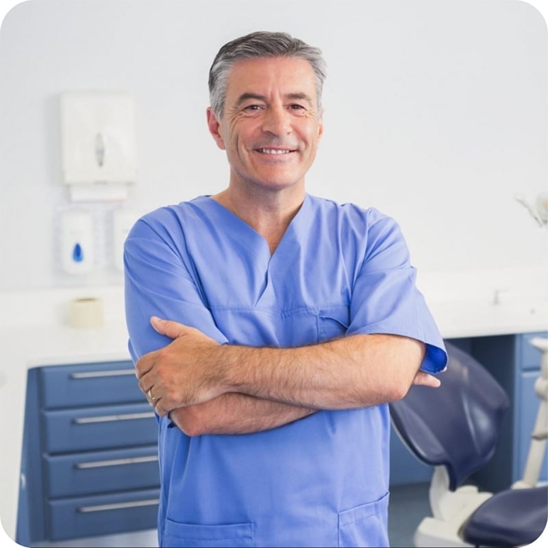 Dentist in scrubs folding arms