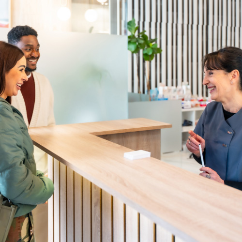 Medical patients being greeted by friendly receptionist