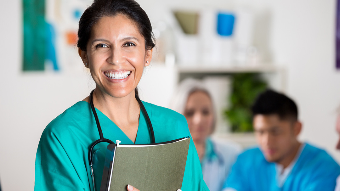 Female doctor with stethoscope smiling at camera