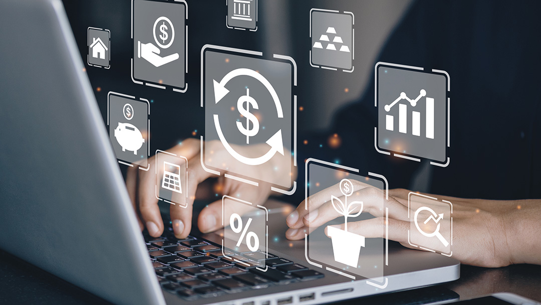 Hands typing at laptop with financial icons overlaid