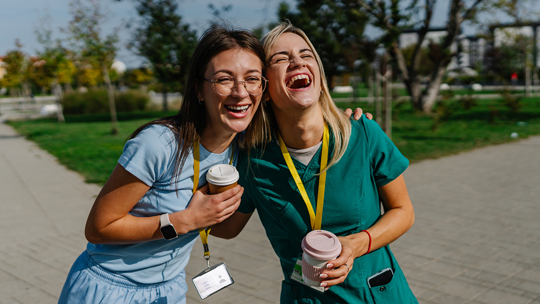 Young doctors outside sharing coffee