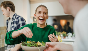 Woman laughing and making salad