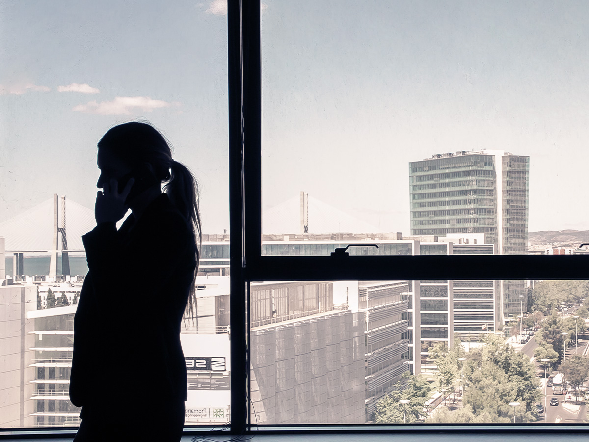 Silhouette of woman on the phone in front of CBD background