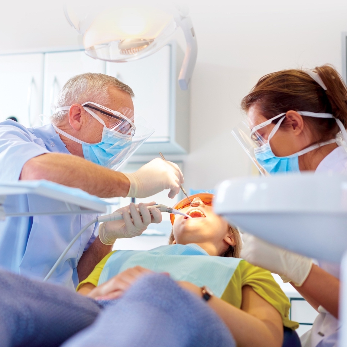 Dentist and assistant working on patient in chair