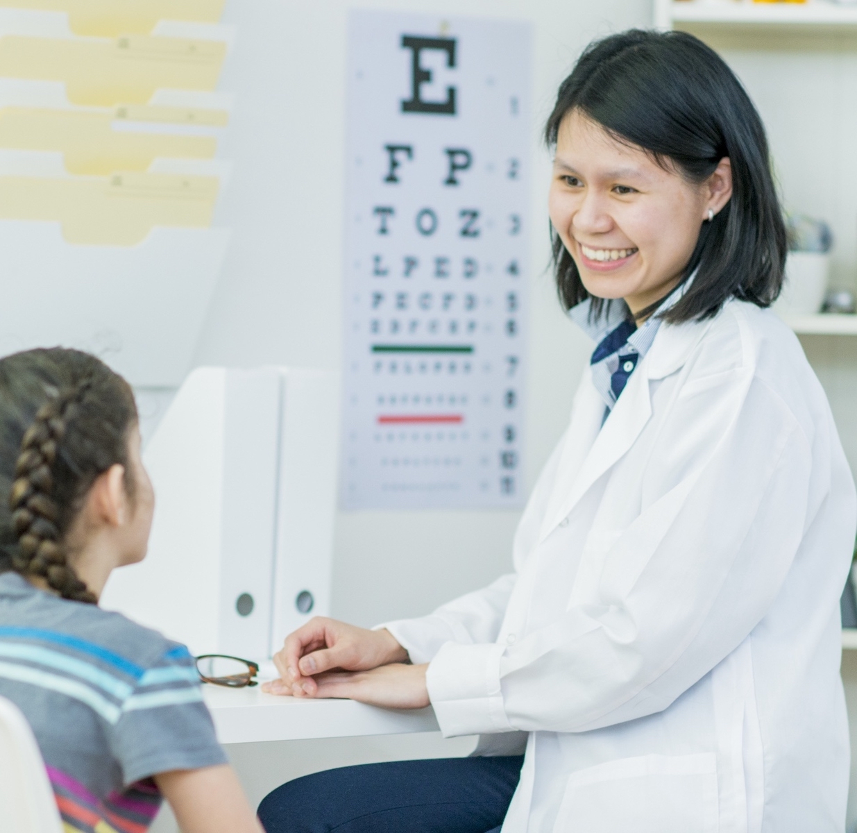 Female optometrist testing child's eyesight