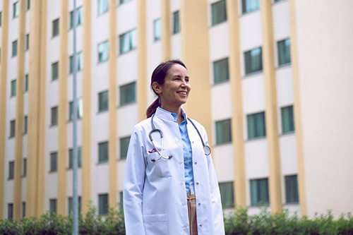 Female doctor standing in front of hospital